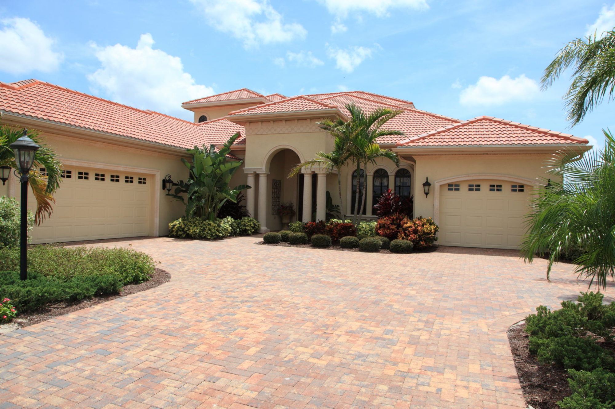 A large light yellow house with two garages and a pink roof near where Realty Medics offers Windermere property management