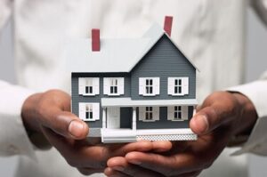 A man in sleeves holding a miniature house